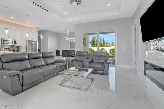 living room featuring a raised ceiling and ceiling fan