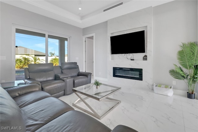 living room featuring a premium fireplace and a tray ceiling