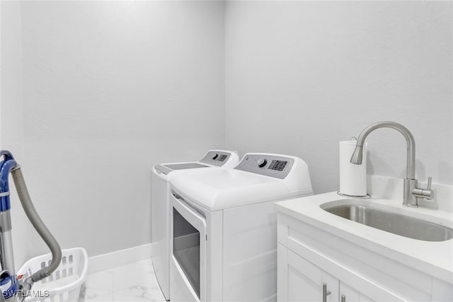 washroom featuring cabinets, sink, and washer and dryer