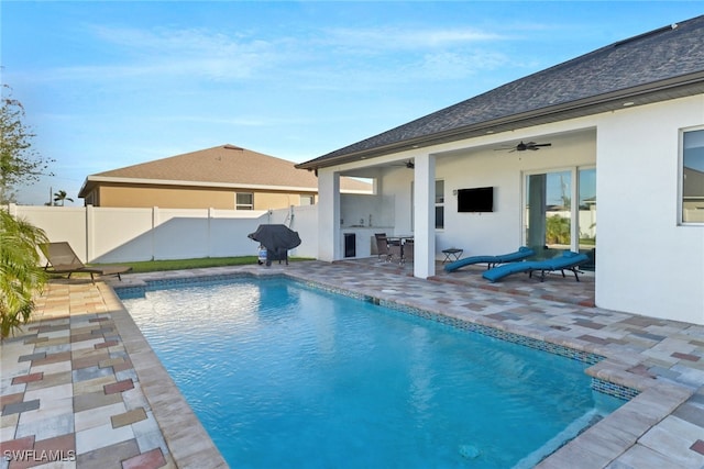 view of swimming pool with area for grilling, ceiling fan, and a patio area