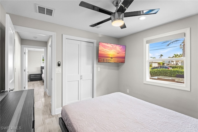 bedroom with ceiling fan, a closet, and light hardwood / wood-style floors