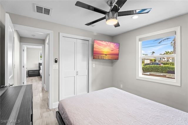 bedroom featuring visible vents, baseboards, a closet, a ceiling fan, and light wood finished floors