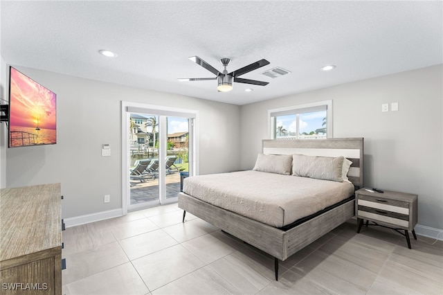 bedroom with access to exterior, ceiling fan, light tile patterned floors, and a textured ceiling