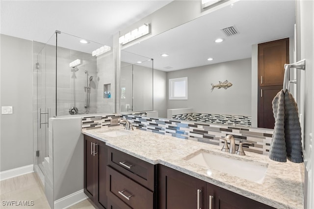 bathroom with tasteful backsplash, vanity, and walk in shower