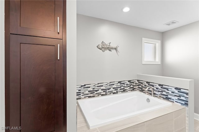 bathroom featuring a relaxing tiled tub