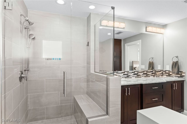 bathroom with vanity, an enclosed shower, and tasteful backsplash