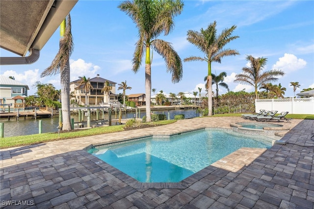 view of swimming pool with a pool with connected hot tub, a dock, a water view, a patio, and fence