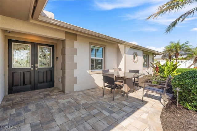 view of patio / terrace with outdoor dining area, french doors, and fence
