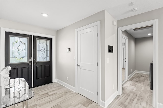 entrance foyer featuring light wood-style flooring, baseboards, and recessed lighting