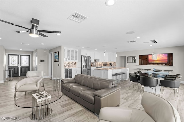 living room with ceiling fan and light wood-type flooring