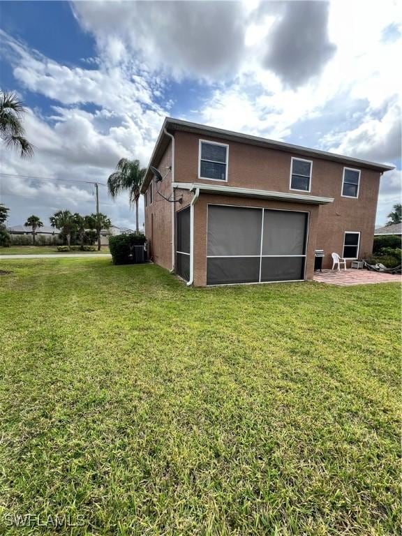 rear view of house with a patio area, a yard, and a garage