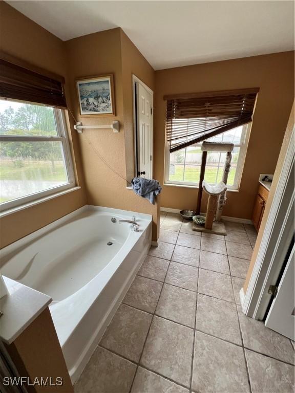 bathroom featuring tile patterned floors, vanity, and a bathing tub