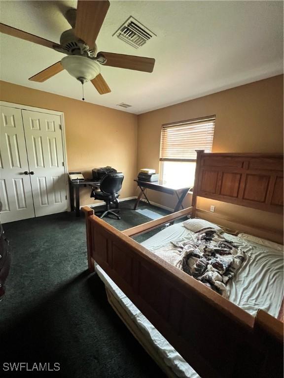 carpeted bedroom with ceiling fan and a closet