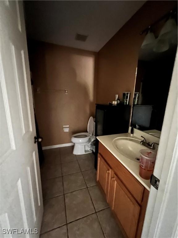 bathroom featuring tile patterned flooring, vanity, and toilet