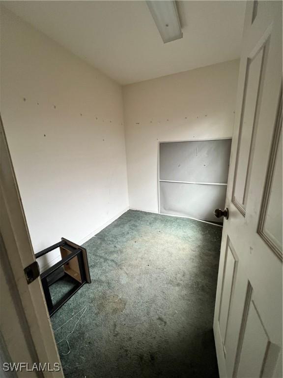 unfurnished room featuring dark carpet