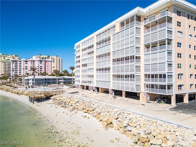 view of building exterior with a water view and a view of the beach