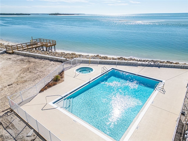 view of swimming pool featuring a community hot tub and a water view