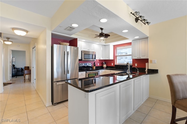 kitchen with white cabinets, kitchen peninsula, sink, and appliances with stainless steel finishes