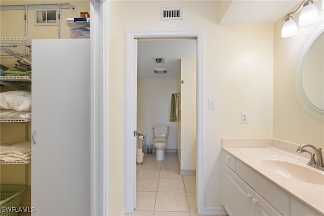 bathroom featuring tile patterned flooring, vanity, and toilet