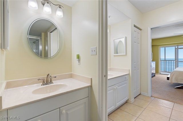 bathroom featuring tile patterned floors, vanity, ceiling fan, and a water view