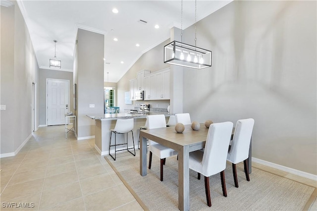 dining area with crown molding, light tile patterned floors, and high vaulted ceiling