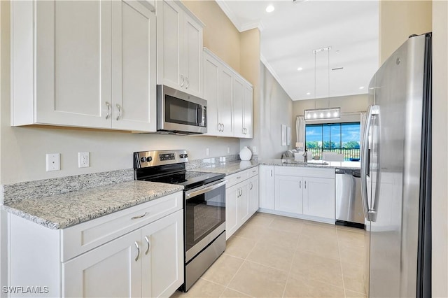 kitchen featuring crown molding, white cabinetry, stainless steel appliances, and light tile patterned floors