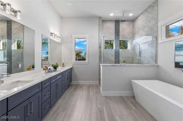 bathroom featuring hardwood / wood-style floors, vanity, and separate shower and tub