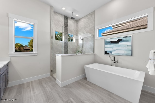 bathroom featuring hardwood / wood-style floors, vanity, and shower with separate bathtub