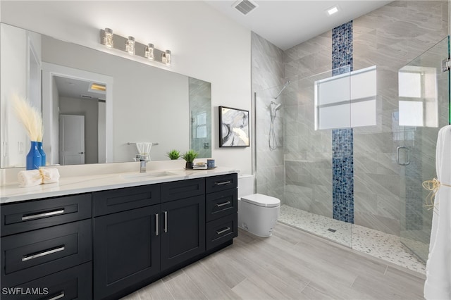 bathroom with vanity, toilet, and a shower with door