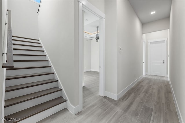 stairs with hardwood / wood-style flooring and ceiling fan