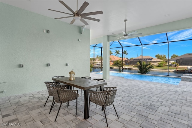 view of swimming pool featuring glass enclosure, ceiling fan, and a patio