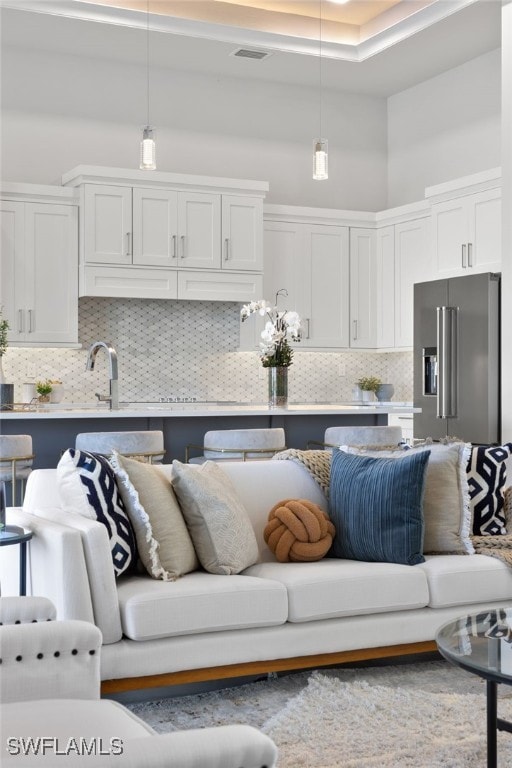 living room with sink and a towering ceiling