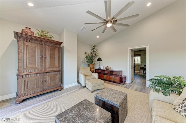 living room with light hardwood / wood-style floors, high vaulted ceiling, and ceiling fan