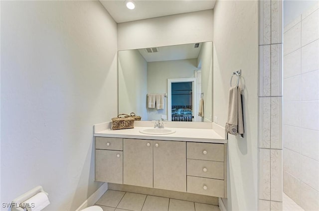 bathroom featuring tile patterned flooring, vanity, and walk in shower