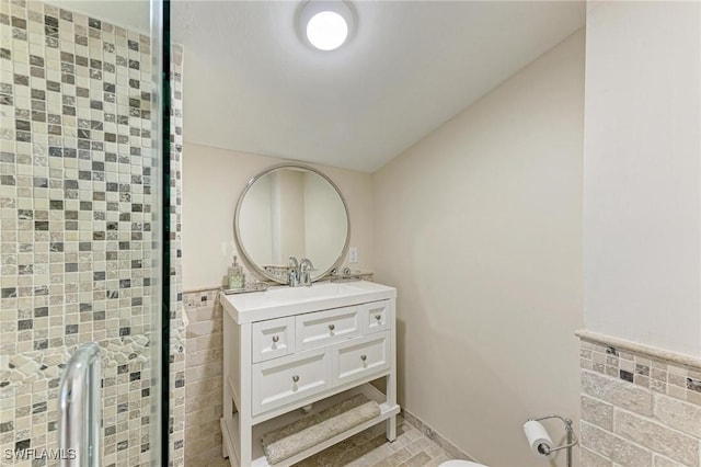 bathroom featuring vanity and tile walls