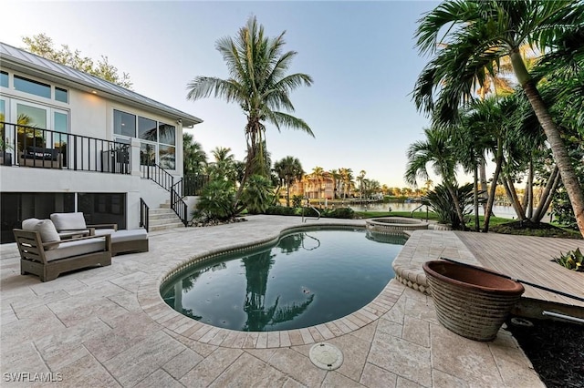 view of pool with a wooden deck, an in ground hot tub, and a patio