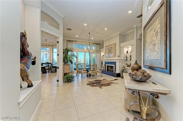 living room with light tile patterned floors, ornamental molding, and a notable chandelier