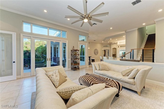 tiled living room featuring crown molding, french doors, and ceiling fan