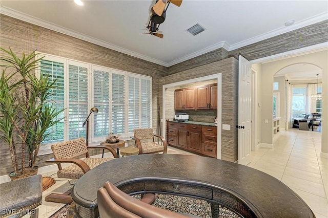 kitchen with ornamental molding, light tile patterned floors, and a healthy amount of sunlight