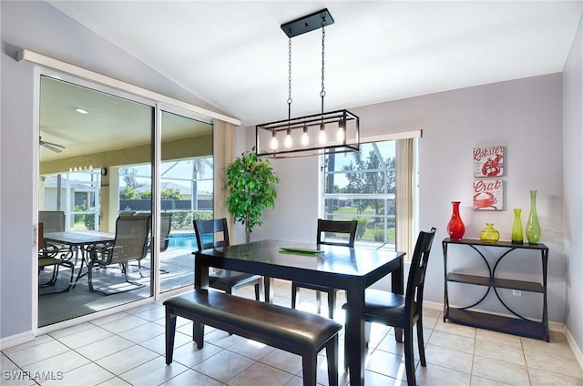 dining area with light tile patterned floors and lofted ceiling