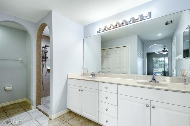 bathroom with tile patterned floors, ceiling fan, vanity, and a tile shower