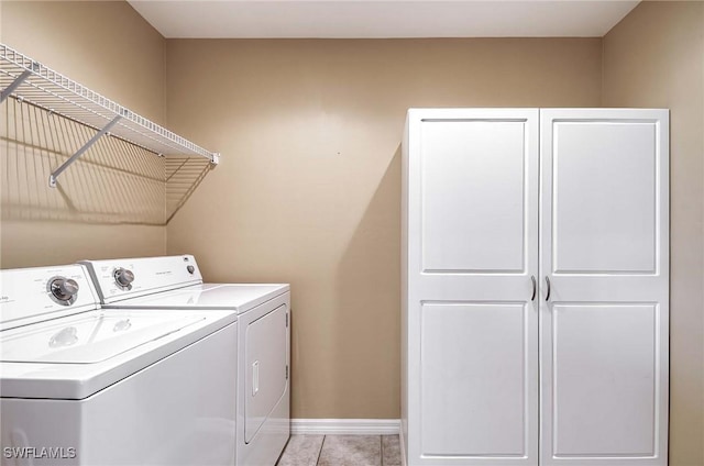 laundry room with light tile patterned floors, cabinets, and independent washer and dryer