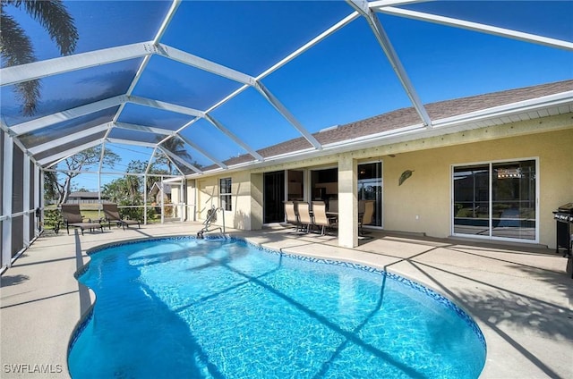 view of pool featuring glass enclosure and a patio