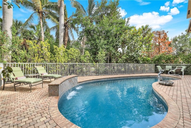 view of pool featuring pool water feature and a patio