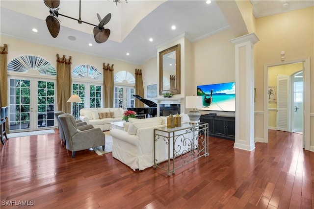 living room with ceiling fan, decorative columns, dark wood-type flooring, and french doors