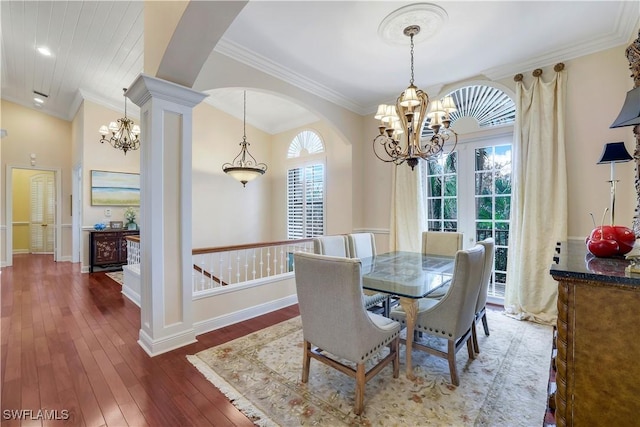 dining space with decorative columns, a wealth of natural light, crown molding, and dark wood-type flooring