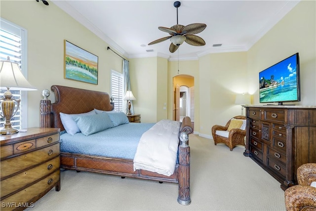 bedroom with multiple windows, ceiling fan, crown molding, and light carpet