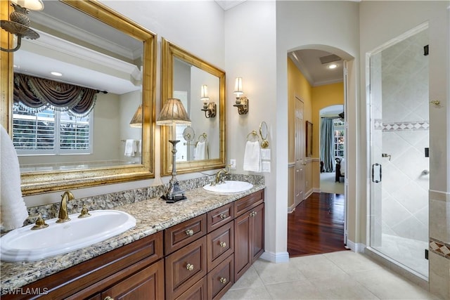 bathroom with tile patterned floors, vanity, ornamental molding, and a shower with door