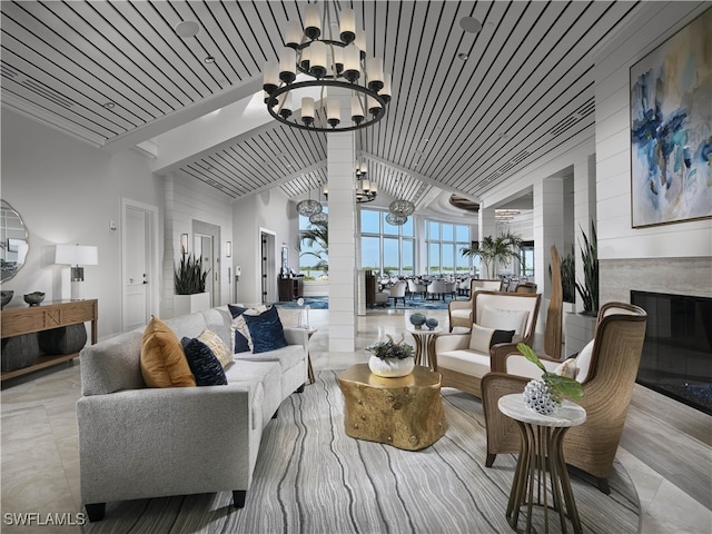 living room with a chandelier, a towering ceiling, and a fireplace