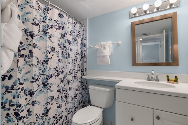 bathroom with a shower with shower curtain, vanity, and toilet